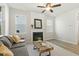 Living room featuring a fireplace, ceiling fan, modern floors, and large windows at 208 Dry Canyon Dr, Wendell, NC 27591
