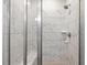 Modern shower featuring marble-style tiling, glass doors, and a built-in bench for comfortable bathing at 208 Dry Canyon Dr, Wendell, NC 27591