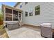 Concrete patio area with a hot tub, grill, and steps up to a screened porch at 2135 Vittorio Ln, Apex, NC 27502