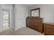Hallway and bedroom with neutral paint, plush carpet, wood dresser and trim, and standard closet at 2135 Vittorio Ln, Apex, NC 27502