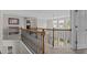 Upstairs hallway features wood and iron railing, neutral paint, plush carpet, and ample natural light at 2135 Vittorio Ln, Apex, NC 27502