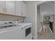 Functional laundry room equipped with modern washer and dryer, cabinet, and white appliances at 2135 Vittorio Ln, Apex, NC 27502