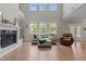 Inviting living room featuring a cozy fireplace, large windows, and comfortable seating at 2135 Vittorio Ln, Apex, NC 27502