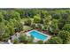 Aerial image of pool with mature trees, lounge seating, shade umbrellas, and clubhouse at 2135 Vittorio Ln, Apex, NC 27502