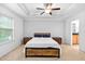 Spacious bedroom with tray ceiling, ceiling fan, neutral carpet, and two windows providing ample light at 2242 Sweet Annie Way, Wake Forest, NC 27587