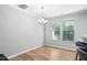 Well-lit dining area featuring wood floors, a chandelier, and natural light from two large windows at 2242 Sweet Annie Way, Wake Forest, NC 27587