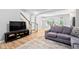 Bright, open living space with hardwood floors, staircase access, and a gray sofa at 2242 Sweet Annie Way, Wake Forest, NC 27587