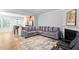Open-concept living room with hardwood floors, a cozy fireplace, and modern gray sofa at 2242 Sweet Annie Way, Wake Forest, NC 27587