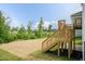 View of the stairs leading to the backyard with green grass and lush trees under a bright sky at 279 Hopewell Branch Ct, Smithfield, NC 27577