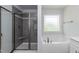 Bright bathroom featuring a separate shower, soaking tub, and a decorative window at 279 Hopewell Branch Ct, Smithfield, NC 27577