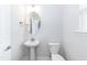 A well-lit bathroom featuring a pedestal sink and modern toilet at 279 Hopewell Branch Ct, Smithfield, NC 27577