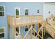A wooden deck attached to a blue house, featuring a staircase and railing for outdoor enjoyment at 279 Hopewell Branch Ct, Smithfield, NC 27577