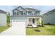 Charming two-story home with blue siding, a gray roof, and a well-manicured lawn, creating an inviting curb appeal at 279 Hopewell Branch Ct, Smithfield, NC 27577