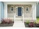 Charming front porch with stone accents, white railings, and a navy front door at 279 Hopewell Branch Ct, Smithfield, NC 27577