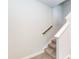 Carpeted stairway with white risers and a wooden handrail, showcasing the home's modern design at 279 Hopewell Branch Ct, Smithfield, NC 27577