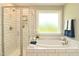 A bright bathroom features a soaking tub, a glass-enclosed shower, and soft, natural light at 3002 Dog Rose Dr # 310, Durham, NC 27703