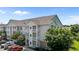 A low-angle shot of a three-story residential building with white balconies and ample parking at 3015 Winston Dr # 117, Burlington, NC 27215