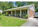 Side view of a single-story home featuring a brick facade, green shutters, and a well-kept lawn at 305 Reynolds N Ave, Durham, NC 27707