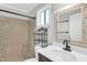 Bathroom featuring white walls, modern fixtures, tiled shower and decorative mirror at 308 Lynn Road, Durham, NC 27703
