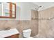 Tiled bathroom featuring a shower with mosaic tile accents and wood vanity with sink at 308 Lynn Road, Durham, NC 27703