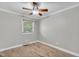 A bedroom with wood tile flooring, a ceiling fan, neutral walls, and a window at 308 Lynn Road, Durham, NC 27703