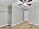 Neutral bedroom with ceiling fan, wood-look floors, closet, and white door at 308 Lynn Road, Durham, NC 27703