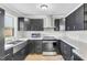 An open kitchen with stainless steel appliances, black cabinets, and marble countertops at 308 Lynn Road, Durham, NC 27703