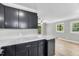 A partial view of the kitchen with black cabinets, marble countertops, and tile flooring at 308 Lynn Road, Durham, NC 27703
