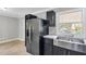 A partial view of the kitchen featuring stainless steel appliances, marble countertops, and stainless steel sink at 308 Lynn Road, Durham, NC 27703