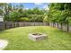 Large backyard featuring a fire pit, surrounded by green grass, and a privacy fence at 3169 Diana Cir, Burlington, NC 27215
