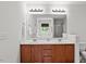 Bright bathroom showcasing double sinks, cherry wood cabinets, framed mirrors, and decorative lighting at 3169 Diana Cir, Burlington, NC 27215
