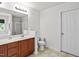 Bathroom featuring cherry wood cabinet, framed mirror, tiled floor, toilet, and white door at 3169 Diana Cir, Burlington, NC 27215