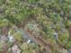 Scenic aerial view featuring multiple properties, a road, and lush trees, showcasing a blend of nature and community at 3418 Carriage Trl, Hillsborough, NC 27278
