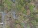 An aerial view of a landscaped home surrounded by lush greenery and trees in a neighborhood at 3418 Carriage Trl, Hillsborough, NC 27278