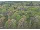 Lush aerial view highlighting the property's extensive woodland, showcasing the natural beauty and privacy at 3418 Carriage Trl, Hillsborough, NC 27278