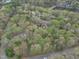 Overhead view featuring a lakeside property with surrounding trees, winding driveways, and a peaceful atmosphere at 3418 Carriage Trl, Hillsborough, NC 27278
