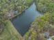 An aerial view of a lake surrounded by houses, trees, and green space at 3418 Carriage Trl, Hillsborough, NC 27278