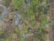 Aerial view showcases a home surrounded by lush trees, blending privacy with a tranquil, natural setting at 3418 Carriage Trl, Hillsborough, NC 27278