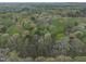 Stunning aerial perspective of a property surrounded by trees, revealing its secluded and peaceful location at 3418 Carriage Trl, Hillsborough, NC 27278