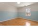 Bedroom featuring two-tone paint, hardwood floors, and bright window at 3418 Carriage Trl, Hillsborough, NC 27278