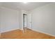 Bedroom with neutral walls, hardwood floors, and doorway at 3418 Carriage Trl, Hillsborough, NC 27278