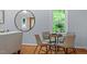 Cozy dining area with a glass table, seating for four, and a large mirror at 3418 Carriage Trl, Hillsborough, NC 27278