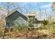 Back exterior view of the home showing the deck and lush greenery at 3418 Carriage Trl, Hillsborough, NC 27278