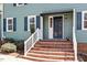 Inviting front entrance with brick steps, white railing, and a stylish door at 3418 Carriage Trl, Hillsborough, NC 27278