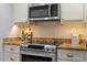 Modern kitchen featuring stainless steel appliances, granite countertops, and stylish cabinetry at 3418 Carriage Trl, Hillsborough, NC 27278