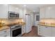 Well-lit kitchen featuring granite countertops, stainless steel appliances, and classic white cabinetry at 3418 Carriage Trl, Hillsborough, NC 27278