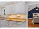 Kitchen with granite countertops, white cabinetry, adjacent to a living area at 3418 Carriage Trl, Hillsborough, NC 27278
