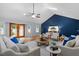 Bright living room with a vaulted ceiling, wood floors, and a stylish blue accent wall at 3418 Carriage Trl, Hillsborough, NC 27278