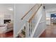 Carpeted staircase with white risers and wood railing, connecting the home's levels at 3418 Carriage Trl, Hillsborough, NC 27278