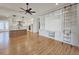 Open living space with hardwood floors, ceiling fan, and built in shelving with rolling ladder at 35 Big Bear Dr, Pittsboro, NC 27312